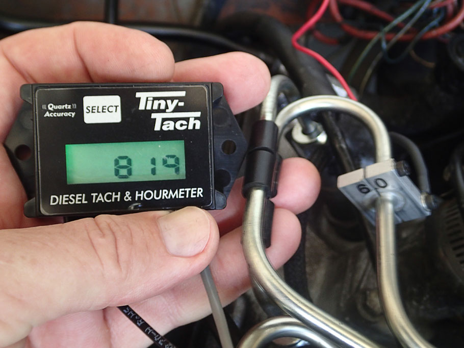 Tachometer display (left) gets input from pieza sensor clamped around injection line (6.0 in right). Our idle speed of 819 rpm looks good.