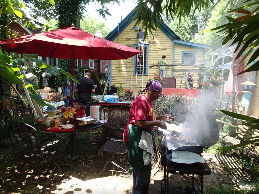 Bertha cooks lunch while volunteers scrape.