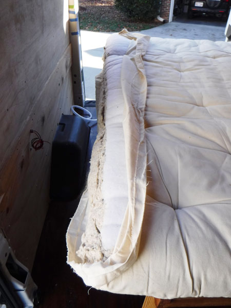 Here Duwan has taken the mattress cover off, opened the inner cover, cut through the thin foam layer and the bedding. She has cut about five inches of mattress off. 