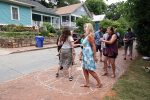 Neighbors participate in a cakewalk on the sidewalk in Cabbagetown Park.